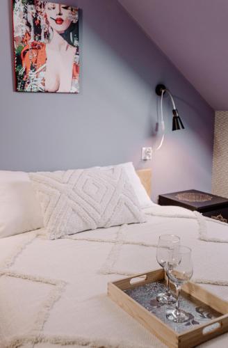a bed with a tray with wine glasses on it at Domki RADAWA na Kliszówce in Radawa