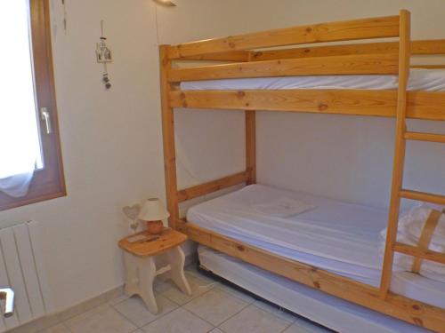 une chambre avec deux lits superposés et une table dans l'établissement T3 cosy avec terrasse, arrêt ski-bus, parking privé, animaux admis, proche centre-village - FR-1-629-96, à Samoëns
