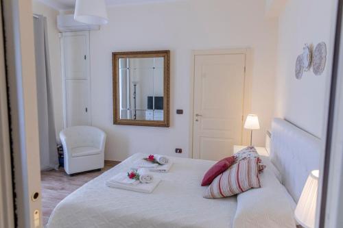 una camera con letto bianco e specchio di Villa Laoconte piscina, jacuzzi e biliardo a Canicattì