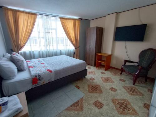 ein Schlafzimmer mit einem Bett, einem Stuhl und einem Fenster in der Unterkunft HOTEL DINO in Pasto