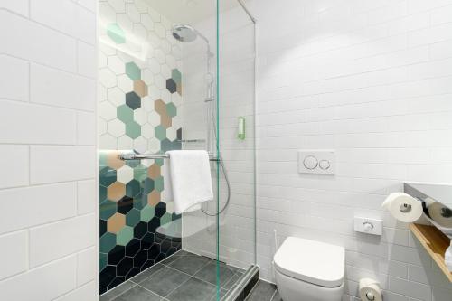 a bathroom with a toilet and a glass shower at Clarion Hotel Vienna South in Vienna