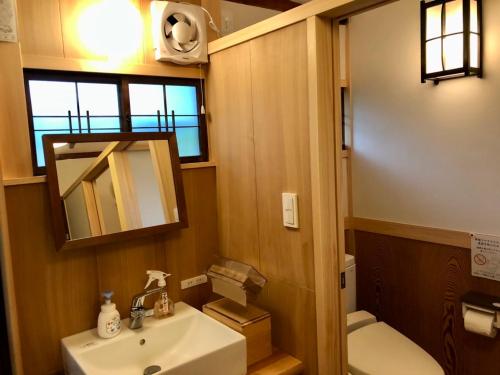 W łazience znajduje się umywalka, toaleta i lustro. w obiekcie Kappo Ryokan Uoichi w mieście Shimada