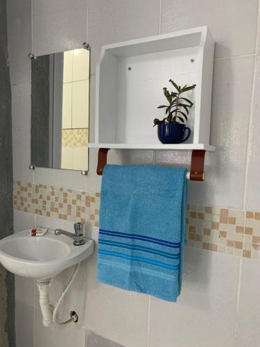 a bathroom with a sink and a blue towel at Pousada Suítes Sete Mares in Guarujá