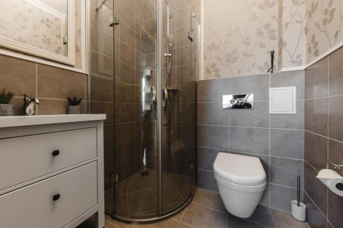 y baño con ducha, aseo y lavamanos. en Charming Apartment in Kaunas Old Town by URBAN RENT, en Kaunas