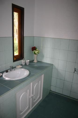 a bathroom with a sink and a vase of flowers at Manora Garden in Phangnga