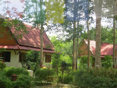 a house with a red roof and some trees at Manora Garden in Phangnga
