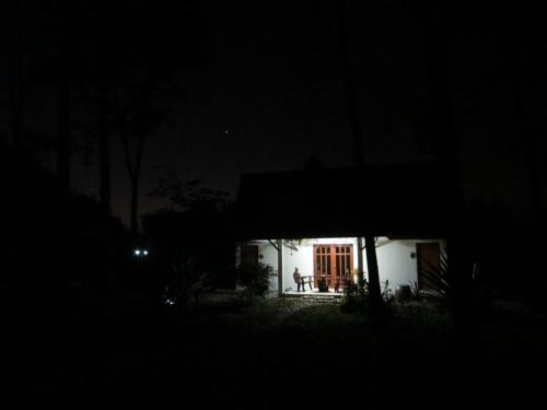 a small white house in the dark at night at Manora Garden in Phangnga
