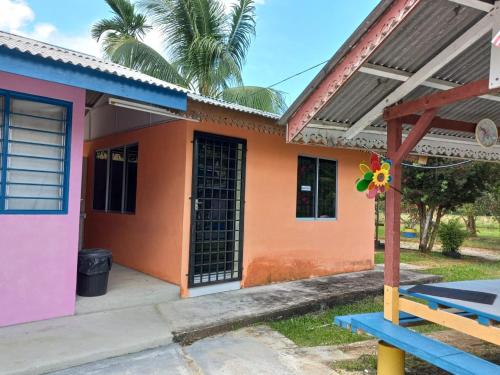 a colorful house with a blue bench in front of it at Tmn Rekreasi Cikgu Haron in Labis