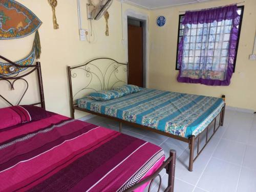 a bedroom with two beds and a window at Tmn Rekreasi Cikgu Haron in Labis