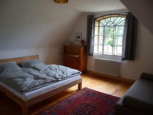 a bedroom with a bed and a window and a rug at Ferien Gut Welzin in Welzin