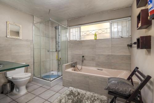 a bathroom with a tub and a toilet and a shower at Eagle Forest inn in Durban