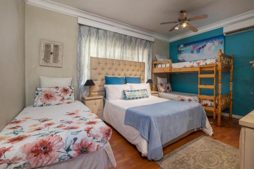 a bedroom with two beds and a bunk bed at Eagle Forest inn in Durban
