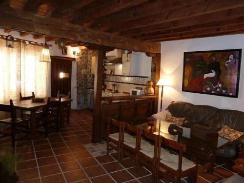 ein Wohnzimmer mit einem Sofa und einem Tisch in der Unterkunft Casa Montes De Toledo in Marjaliza
