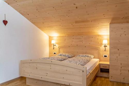 1 dormitorio con 1 cama grande de madera en una habitación en Appartamento Confolia 2, en La Valle