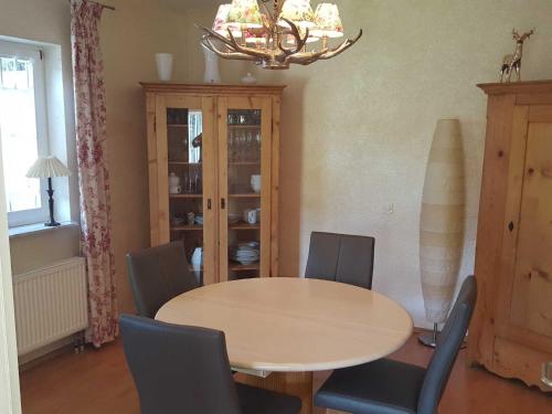 ein Esszimmer mit einem Tisch, Stühlen und einem Kronleuchter in der Unterkunft Ferienwohnung Dorn in Lautertal