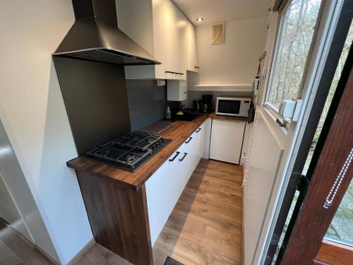 a small kitchen with a stove top in a tiny house at Bos Chalet Durbuy in Durbuy