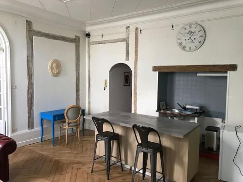 a kitchen with a table and chairs and a clock at Nid douillet bord de Loire in Blois