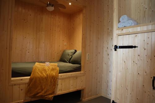a sauna with a bed in a wooden wall at Vakantiehuisje Jipué met sauna en bubbelbad. in Bruchterveld