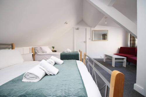 1 dormitorio con 2 camas y sala de estar con sofá en Stunning 4 Bedroom Flat near City Centre en Swansea