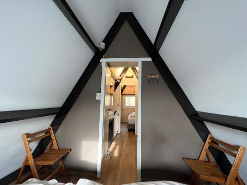 a attic room with two chairs and a doorway at Bos Chalet Durbuy in Durbuy