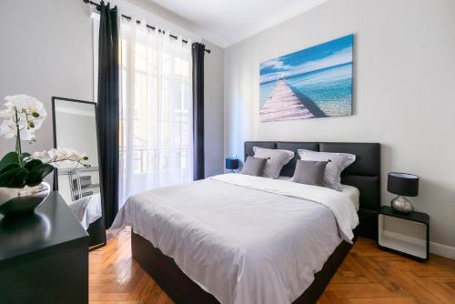 a bedroom with a large bed and a large window at Nice Central Art Deco Flat 45 m² in Nice