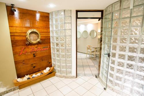 una habitación con una pared de bloqueos de cristal en el baño en Porty Brasil Hotel, en Paranaguá