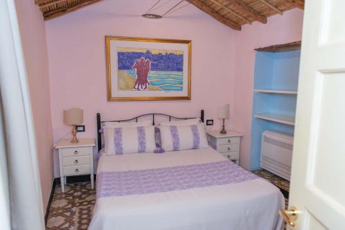 a bedroom with a white bed and two night stands at Beautiful house in Orosei in Orosei