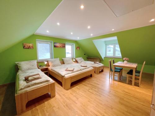 Habitación verde con 4 camas y mesa en Ubytování v soukromí s bazénem Tři Splavy, en Čeladná
