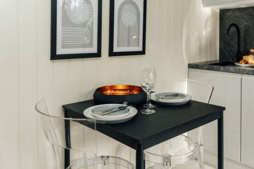 een zwarte tafel met borden en wijnglazen erop bij Cuckoo’s Hideaway in Buckinghamshire