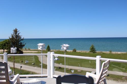 a view of the ocean from a balcony with chairs at The Purple Martin Lakeside Inn Bird Sanctuary on Lake Huron in Rogers City