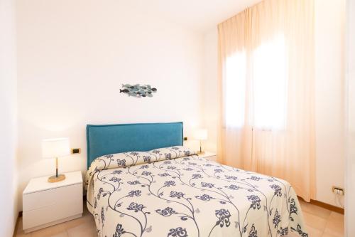 a bedroom with a bed with a blue and white comforter at Riviera Residence in Marina di Pietrasanta
