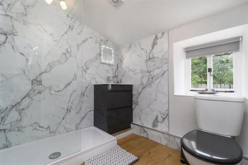 a bathroom with a black and white marble wall at Ceunant Bach in Bethesda