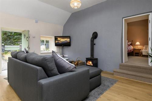 a living room with a couch and a fireplace at Ceunant Bach in Bethesda
