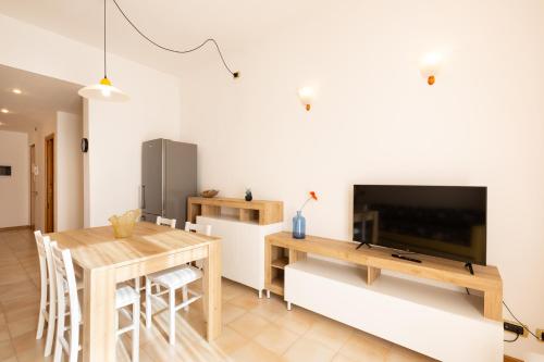 a living room with a dining table and a tv at Riviera Residence in Marina di Pietrasanta