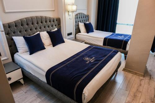a hotel room with two beds with blue pillows at Loft Airport Hotel's in Arnavutköy