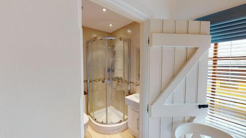 a bathroom with a shower with a toilet and a sink at Stables Barn in East Budleigh