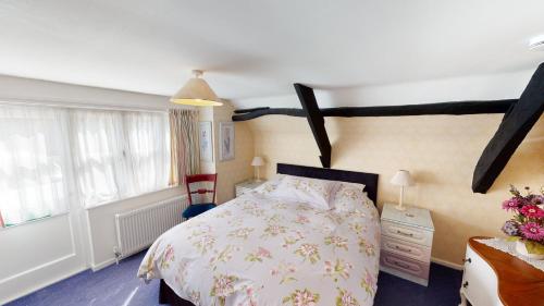 1 dormitorio con 1 cama, vestidor y ventana en Cider Cottage en Sidmouth