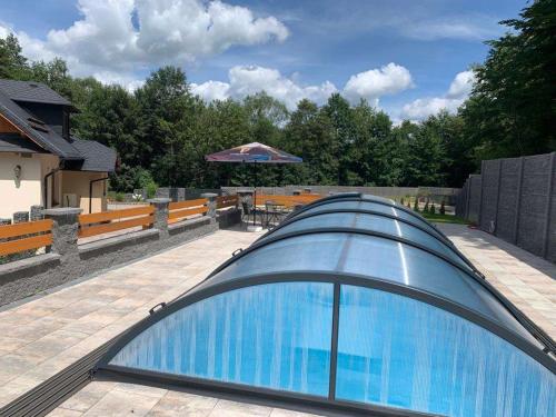 a swimming pool with a glass roof on a patio at Ubytování v soukromí s bazénem Tři Splavy in Čeladná