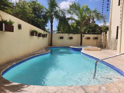 a swimming pool with blue water in a backyard at Hotel La Casona MC in La Romana