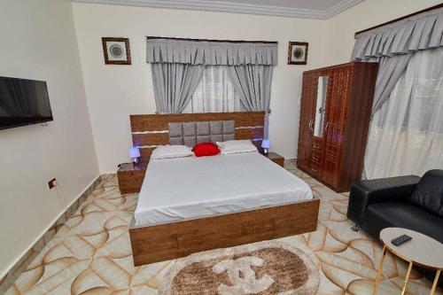 a bedroom with a large bed and a couch at POMAA VILLA in Kumasi
