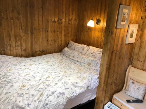 a bedroom with a bed in a wooden wall at Goodwin Farm in Northiam