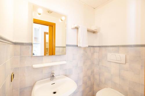 a bathroom with a sink and a toilet and a mirror at Riviera Residence in Marina di Pietrasanta