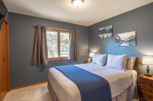 a bedroom with a bed with blue walls and a window at Family Home W/ 2 King, 2 Queen Beds + Game Room in Bemidji