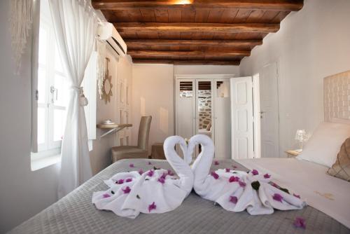 two swans wrapped in towels sitting on a bed at Seablue Town Maisonette Mykonos in Mýkonos City