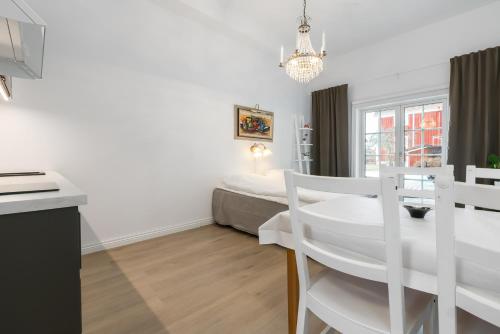 a white room with a bed and a table and chairs at Flygeln in Leksand