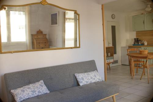 un salon avec un canapé et un miroir dans l'établissement Appart coeur de village - proche des criques, à Port-Vendres