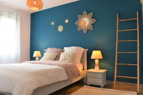 1 dormitorio con una pared azul y 1 cama en L'Acacia en Bénesse-Maremne