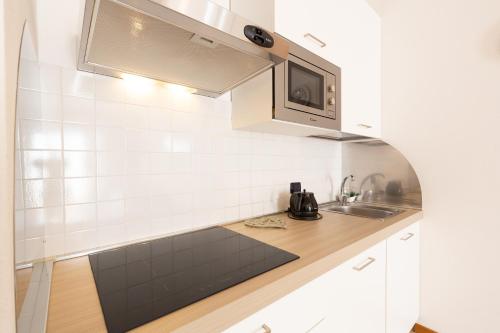 a small kitchen with a sink and a microwave at Riviera Residence in Marina di Pietrasanta