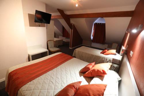 Cette chambre comprend 2 lits et une télévision. dans l'établissement Logis Le Bourguignon, à Bèze