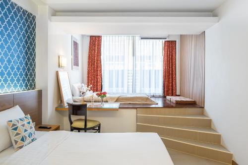 a bedroom with a bed and a desk and a window at P2 Boutique in Bangkok